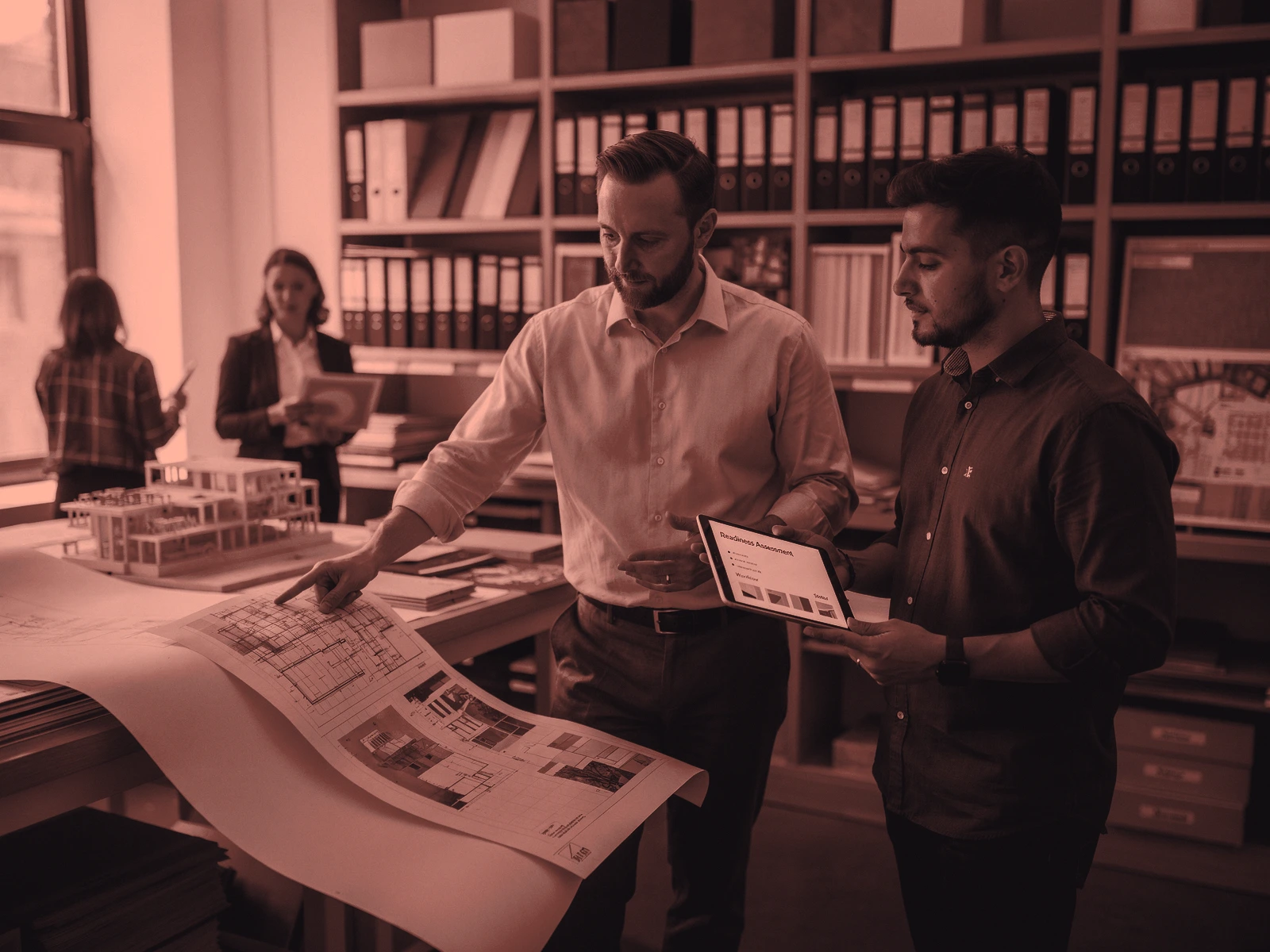 A consultant and operations director assess a digital workflow while walking through an active professional-services studio