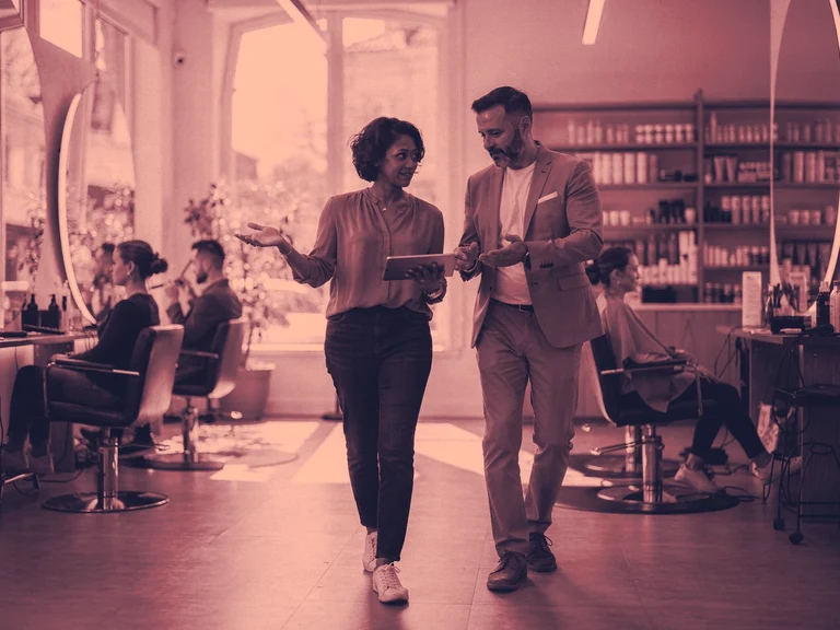 A consultant and salon owner review a booking and CRM workflow