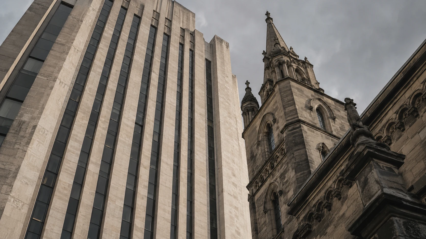 Modern pale office tower beside the carved stonework of an older building